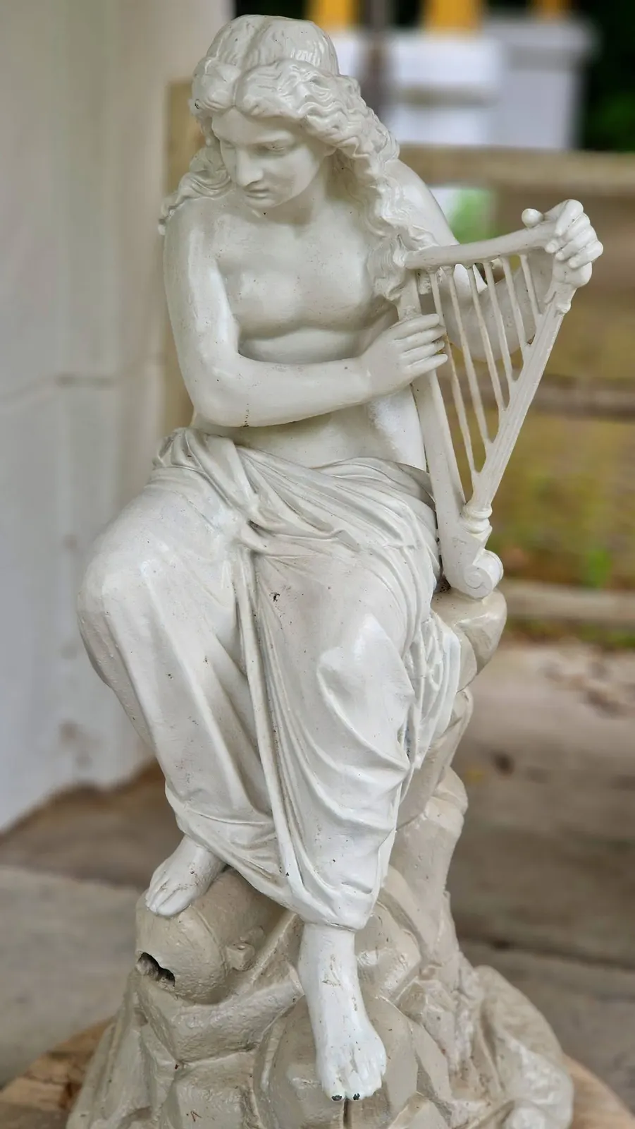 Sculptură feminină cu harpă, detaliu de patrimoniu decorativ.