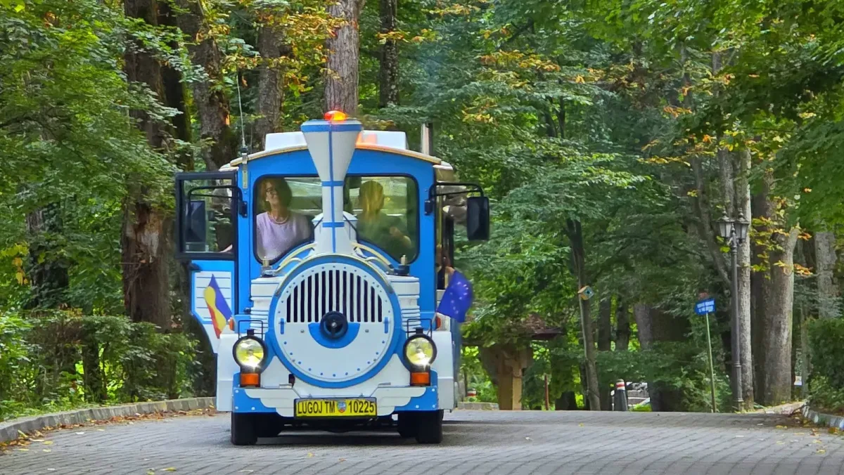 Trenulețul turistic al stațiunii pe o alee împădurită din Băile Govora.