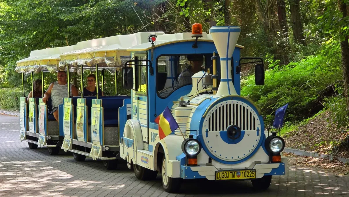 Trenulețul turistic transportând vizitatori pe aleile stațiunii.